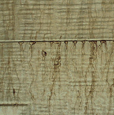 Close up image of a surface that has tan or brownish streaks or spots.