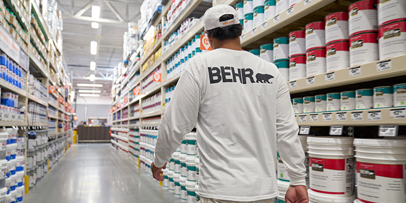 Desktop view of a pro painter spray painting the exterior wall of a house.
