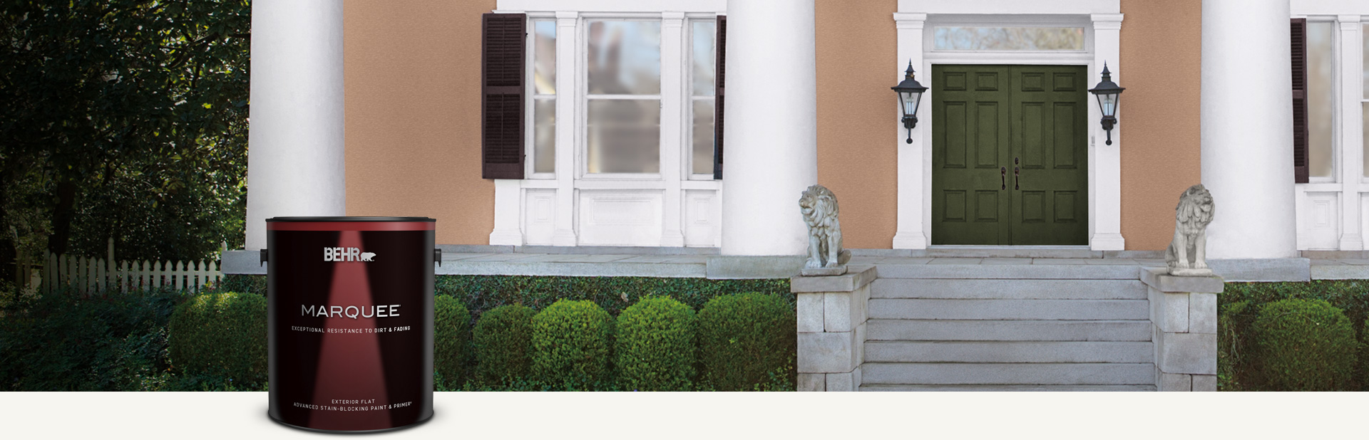 Tan house exterior with a can of Behr Marquee Exterior Flat in foreground