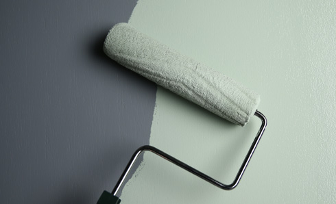 Person rolling paint on a wall